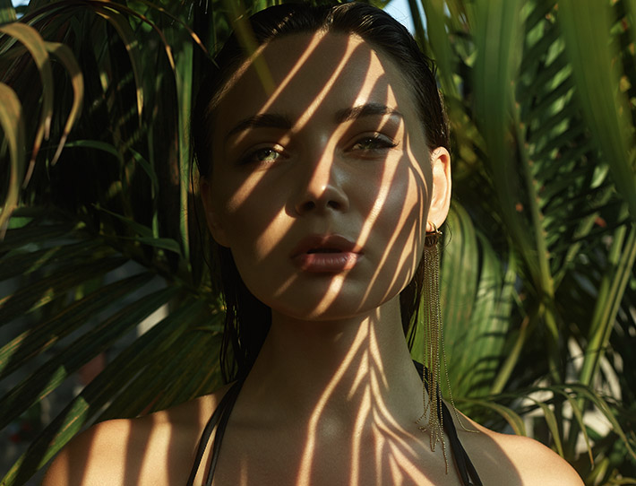 Woman shadowed by palms.